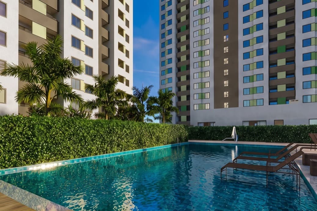 Piscina do Ritmos de Pilares cercada de palmeiras, com as torres residenciais ao fundo